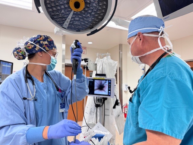 Heidi Woods - thumbnail_IMG_3890 Doctor and nurses working on patient in an operating room using a camera scope looking at a screen